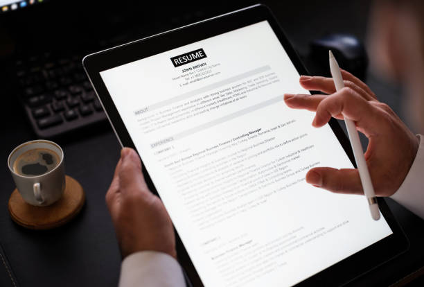 businessman reading a resume on digital tablet to hire correct personnel - recruitment application form occupation employment issues imagens e fotografias de stock