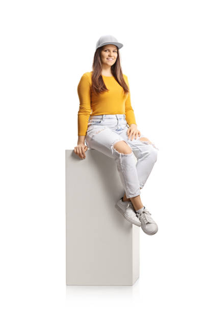istock Young female sitting on a white column and smiling at camera 1303507086