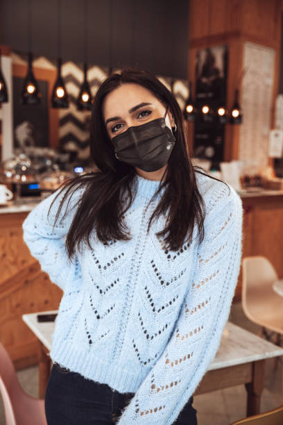 istock Woman wearing a black face mask in a cafe 1303508455