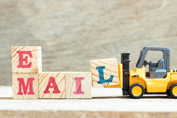 istock Toy forklift hold letter block l to complete word e mail on wood background 1303508482