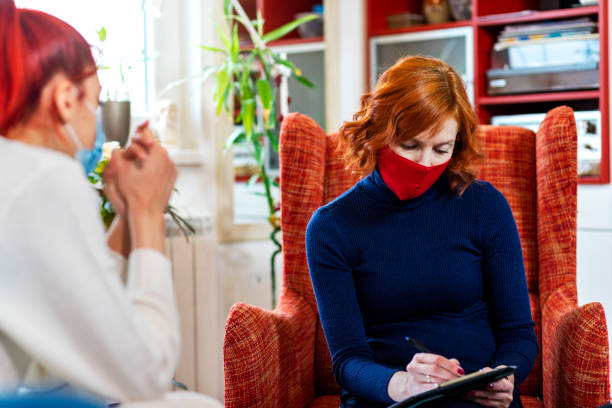istock Female psychotherapist with protective face mask during session 1303511549