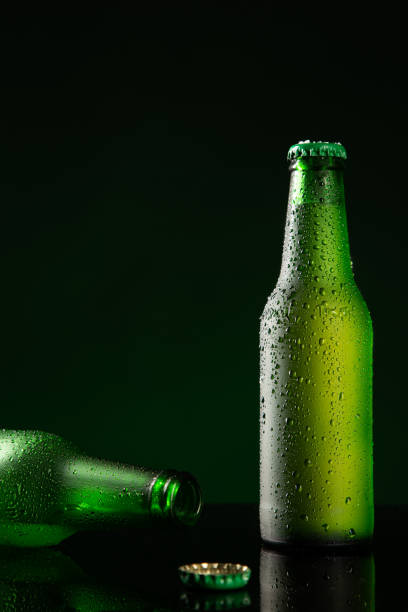 istock Two bottle of cold beer with water drop on dark green background with copyspace. Vertical format. 1303511664