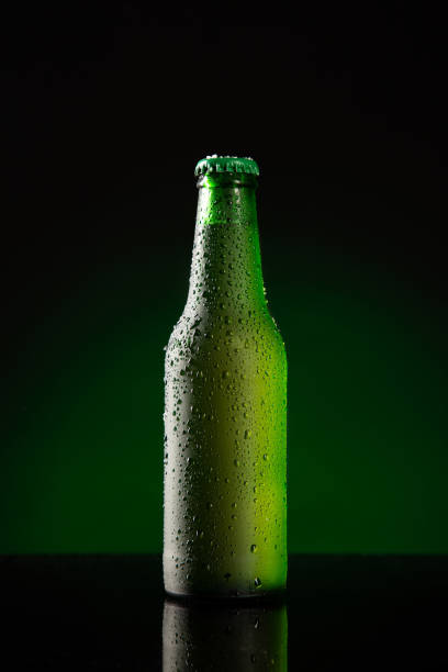 istock Bottle of cold beer  on dark green background. Vertical format.t. 1303511700