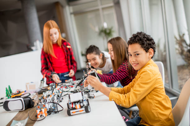 istock Happy kids programming electric toys and robots at robotics classroom 1303512622