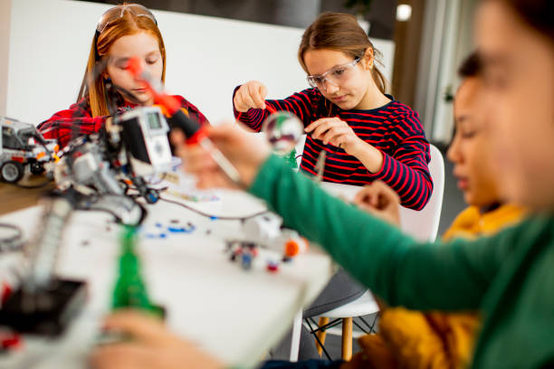 istock Happy kids programming electric toys and robots at robotics classroom 1303512632