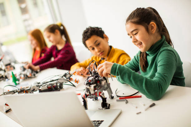 istock Happy kids programming electric toys and robots at robotics classroom 1303512645