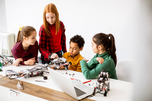 istock Happy kids programming electric toys and robots at robotics classroom 1303512685