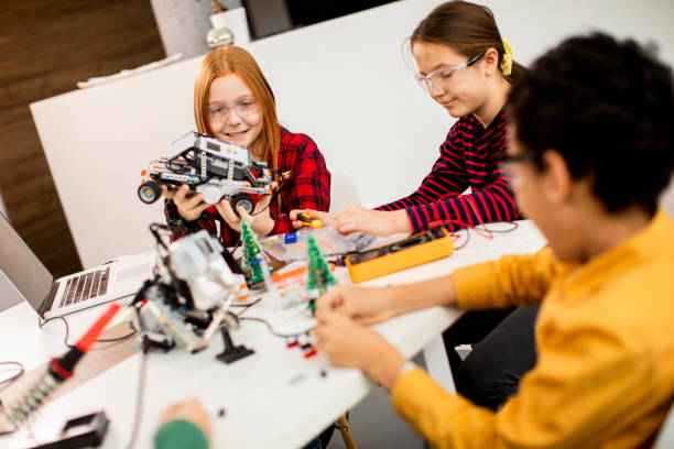 istock Happy kids programming electric toys and robots at robotics classroom 1303512686