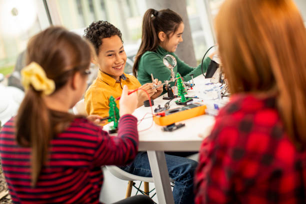 istock Happy kids programming electric toys and robots at robotics classroom 1303512716