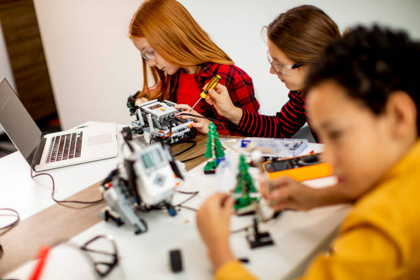 istock Happy kids programming electric toys and robots at robotics classroom 1303512728