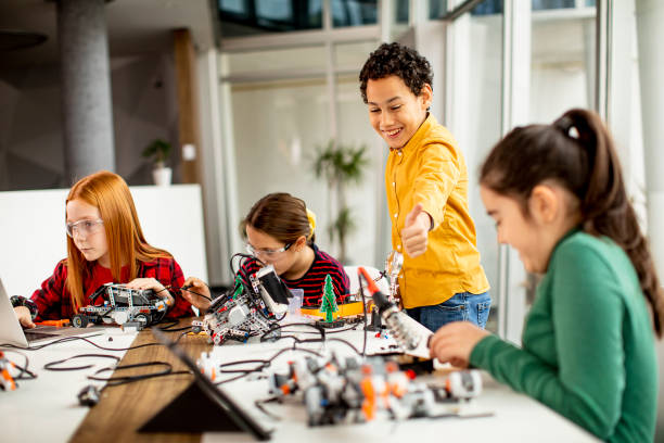 istock Happy kids programming electric toys and robots at robotics classroom 1303512748