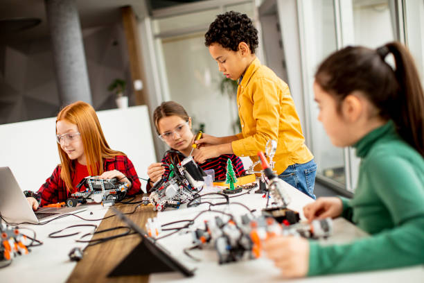 istock Happy kids programming electric toys and robots at robotics classroom 1303512755