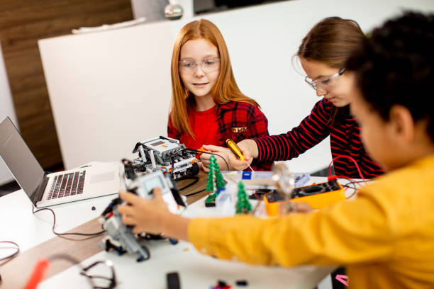 istock Happy kids programming electric toys and robots at robotics classroom 1303512756
