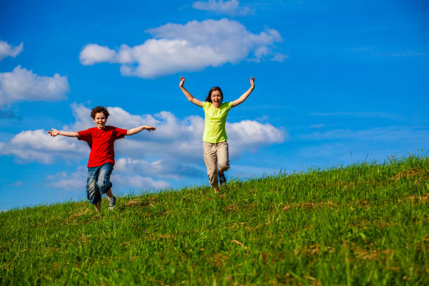istock Girl nad boy running on green meadow 1303513992