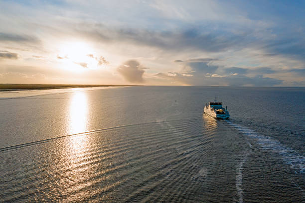 antenne du ferry d’ameland arrivant à holwerd aux pays-bas au coucher du soleil - ferry photos et images de collection