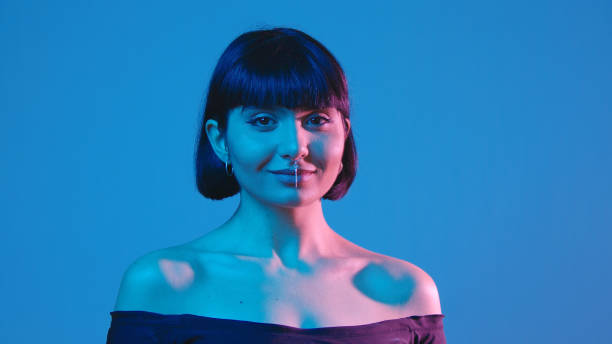 istock Young woman smile isolated on blue neon copyspace 1303517214