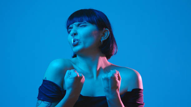istock Young woman rejoices isolated on blue neon copyspace 1303517388