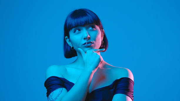 istock Young woman smile think aha idea eureka isolated on blue neon copyspace 1303517508