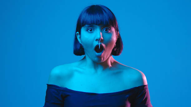 istock Young woman scared schocked isolated on blue neon copyspace 1303517544
