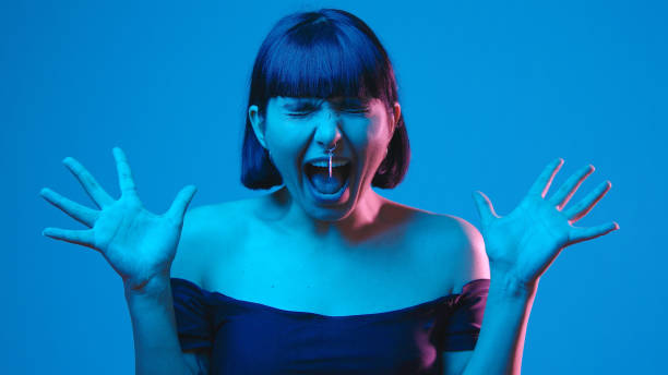 Young woman scream yell isolated on blue neon copyspace