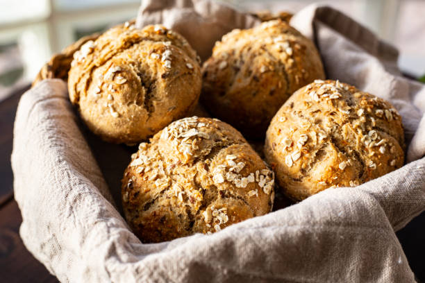 istock Breakfast rolls in a bread basket on wooden plank close up 1303518547