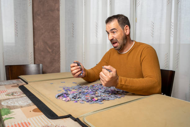 istock Bearded man in an orange sweater screaming desperately unable to complete a puzzle 1303518551