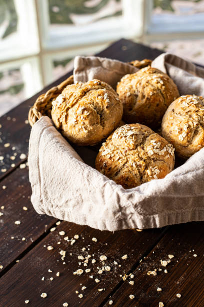 istock Breakfast rolls in a bread basket on wooden plank 1303518586