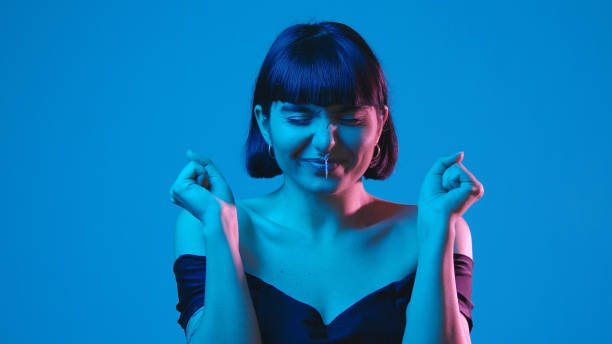 Young woman make a wish isolated on blue neon copyspace