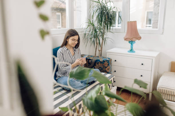 istock Young woman using a smartphone and relaxing at home 1303518774