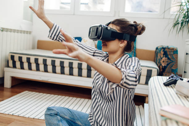 istock Girl playing a virtual game with a virtual reality headset 1303518798