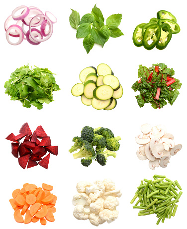 Variety of fresh vegetables chopped top down, isolated white background