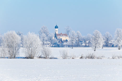 Bavarian snow landscape with the St. Georg Church near Bad Toelz in Upper Bavaria, Germany.