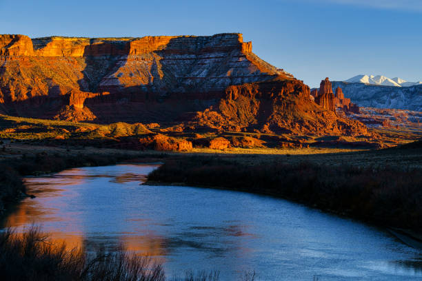 Western Sunset Fisher Towers La Sal Mountains Western Sunset Fisher Towers La Sal Mountains - Scenic view in winter along the Colorado River with towering red rock spires and rock towers. View of the La Sal Mountains in background covered in fresh snow. Moab, Utah USA. la sal mountains stock pictures, royalty-free photos & images