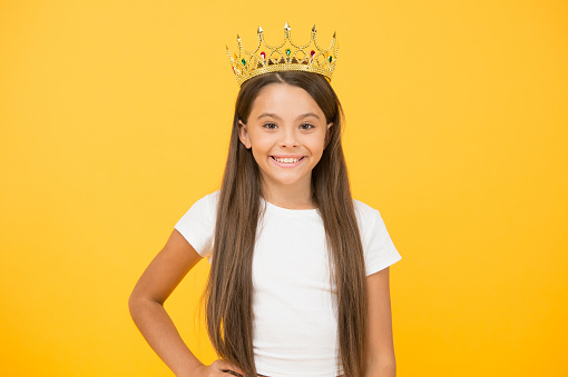 Portrait of a smiling young woman with a crown on her head, isolated on white background