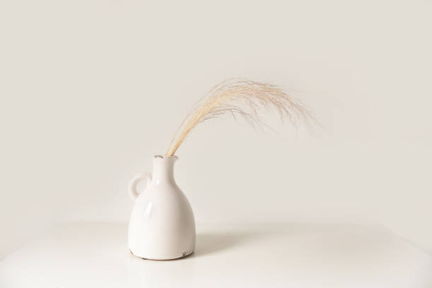 istock White vase with dried gold flowers on a white background 1303527935