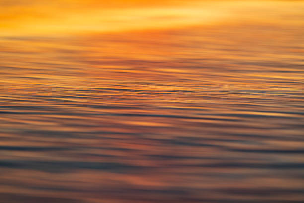 крупным планом текстуры солнечного света на поверхности воды - coral water sunset usa стоковые фото и изображения