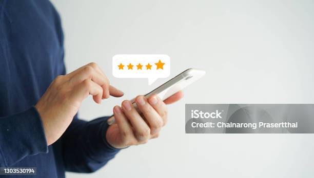 Close Up On Customer Man Hand Pressing On Smartphone Screen With Five Star Rating Feedback Icon And Press Level Good Rank For Giving Best Score Point To Review The Service Technology Business Concept Stock Photo - Download Image Now