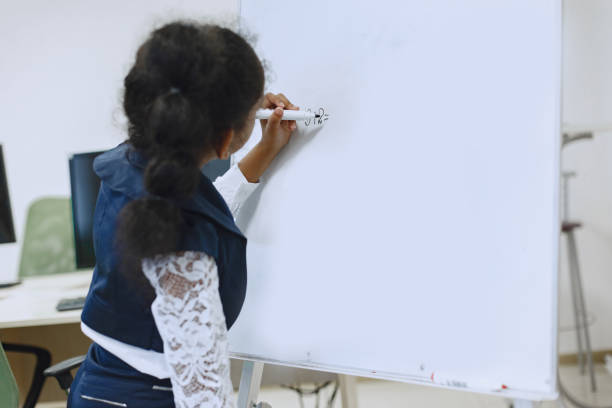 istock African girl writes with a marker on a flipchart. 1303532537