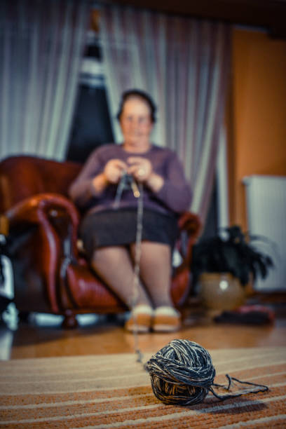 Senior woman knitting at home