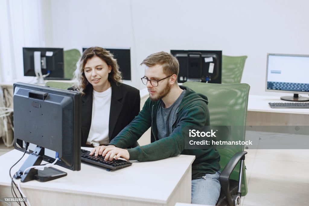 People Sitting At A Table In A Computer Room Stock Photo - Download ...