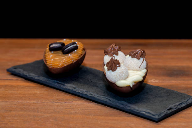 istock Chocolate easter eggs on top of black stone with wooden background 1303536393