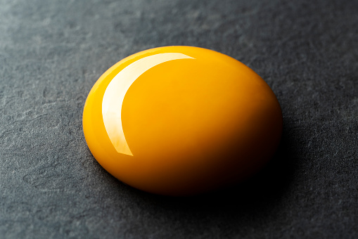 Egg yolk on black background
