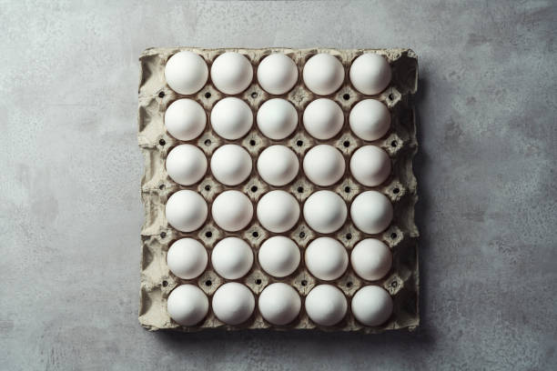 istock Box of white eggs on gray background 1303537331