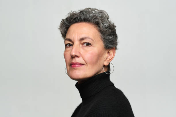 eine schöne frau, die im profil auf die kamera schaut. - geschäftsleute fotos stock-fotos und bilder