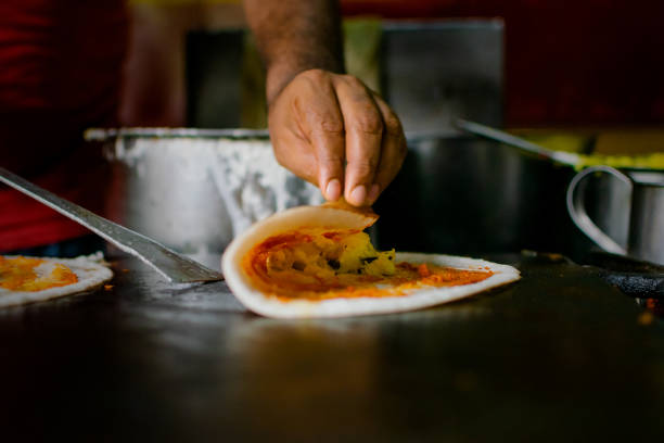 Masala Dosa making on black pan. Masala dosai or masale dose or masaldosa is a variation of the popular South Indian dosa, which has its origins in Tuluva Mangalorean cuisine of Karnataka. It is made from rice, lentils, potato, fenugreek, and curry leaves, and served with chutneys and sambar.