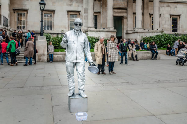 An unidentified busking mime performs on Trafalgar Square, Charing Cross, London, UK. Street performer spray painted silver is the entertainment for the touristsA living statue is a street artist who poses as a statue or mannequin, usually with realistic statue-like makeup, sometimes for hours at a time. ... As with all performing arts, living statue performers may perform as buskers.