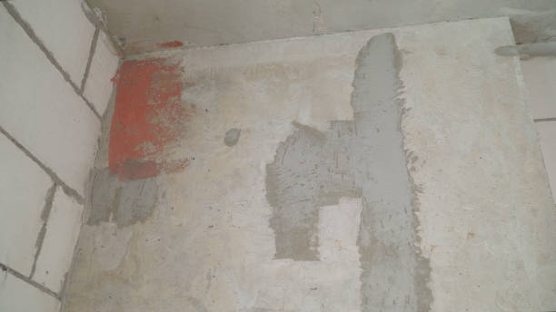 istock Applying pink plaster to the wall. Pink concrete background with abstract textured pattern applied to the surface. 1303542914