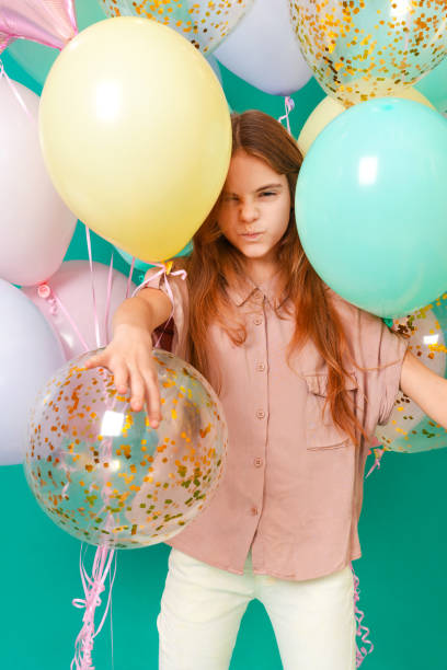 1 ragazza bianca 10 anni con palloncini rosa, gialli, blu sorrisi - 10 11 years cheerful happiness fun foto e immagini stock