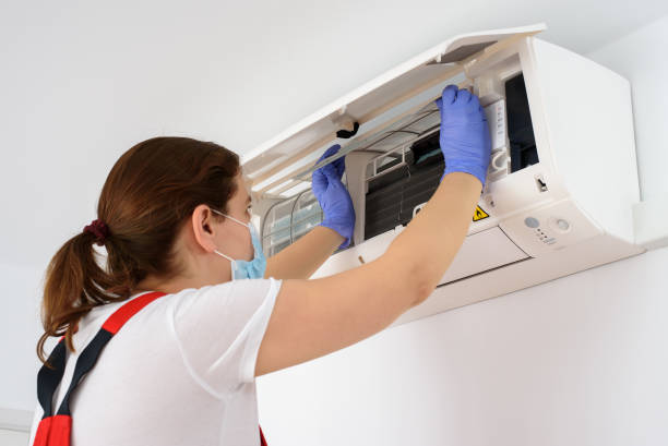 istock Female technician wearing face mask and cleaning air conditioner 1303543446