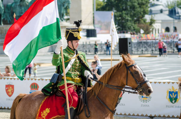 uomo in uniforme militare tradizionale su un cavallo e portatore della bandiera ungherese, festival delle giornate dell'eredità, budapest - hungarian flag foto e immagini stock